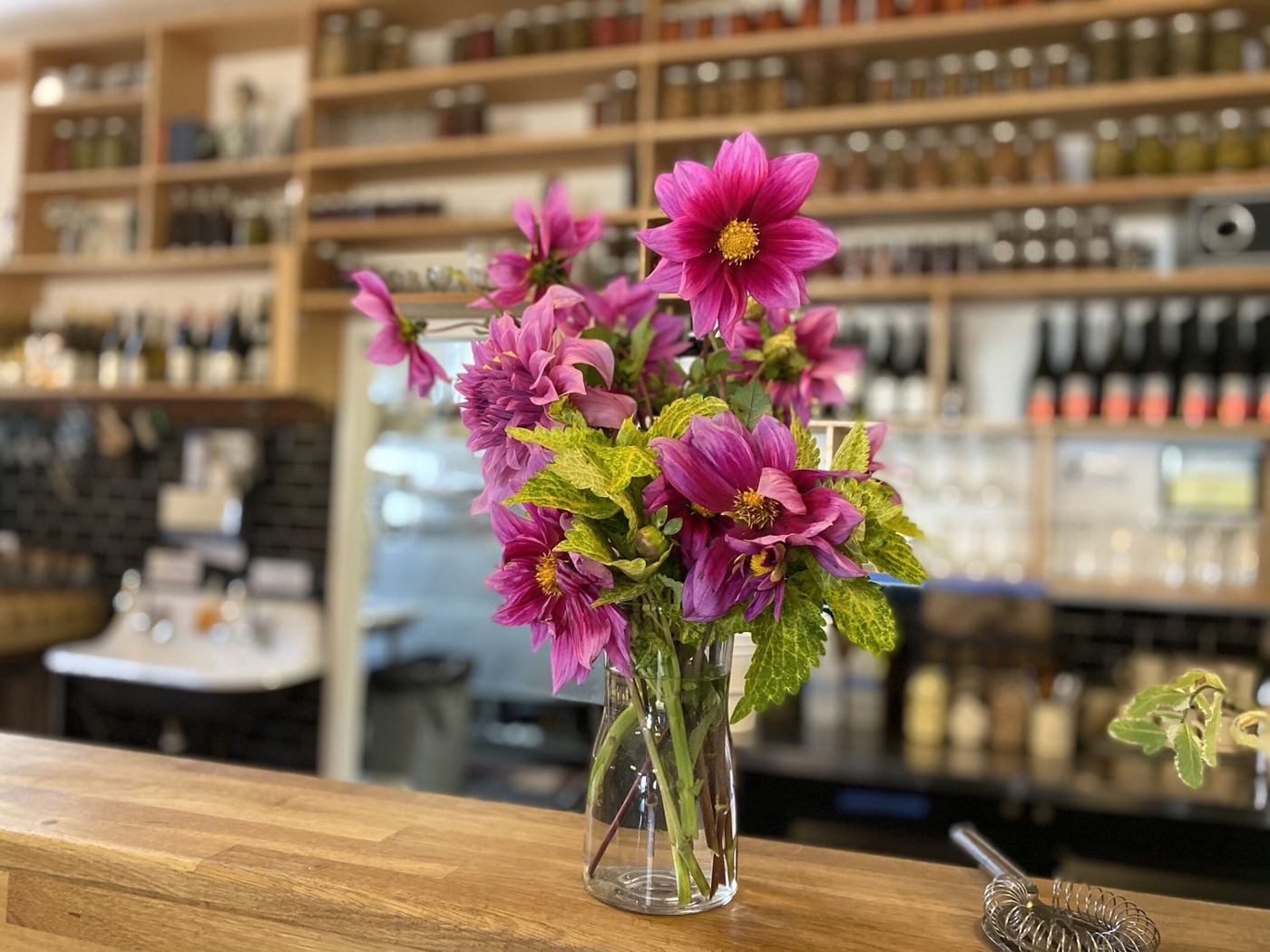 Fresh flowers on the bar in front of the bottle shelf